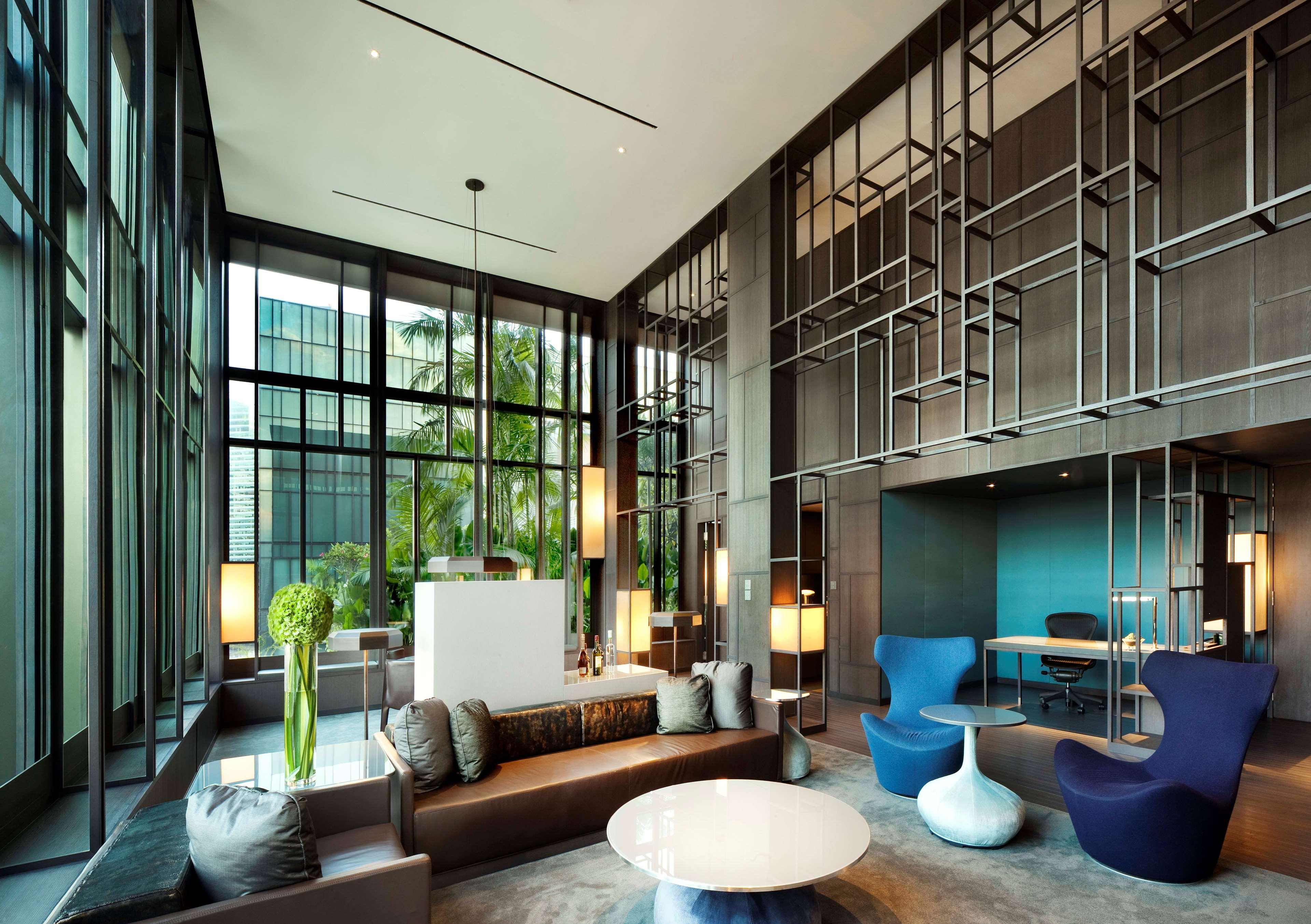 Parkroyal Collection Pickering, Szingapúr Kültér fotó The photo shows a modern lobby or lounge area. It features large windows that allow plenty of natural light to flood the space, creating an open and airy atmosphere. The interior design includes a combination of comfortable seating arrangements with 