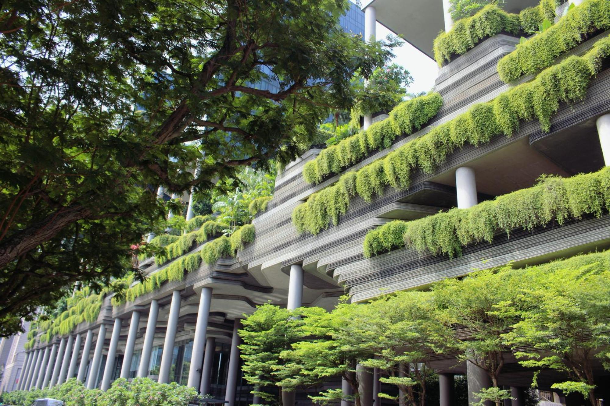 Parkroyal Collection Pickering, Szingapúr Kültér fotó The photo shows a modern building with a unique architectural design. The structure features multiple levels supported by several columns, and it is adorned with abundant greenery. Plants are cascading down from the balconies or ledges, giving the bu